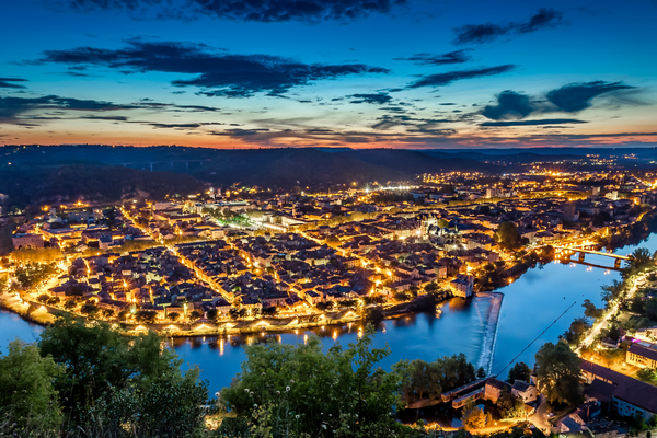 Twilight over Cahors, lit streets along river bend, from a high vantage point.