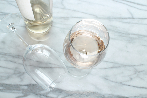 Image featuring three glasses of Moscato wine, with one glass empty and artistically laid on its side, showcasing the variety and elegance of Moscato wines