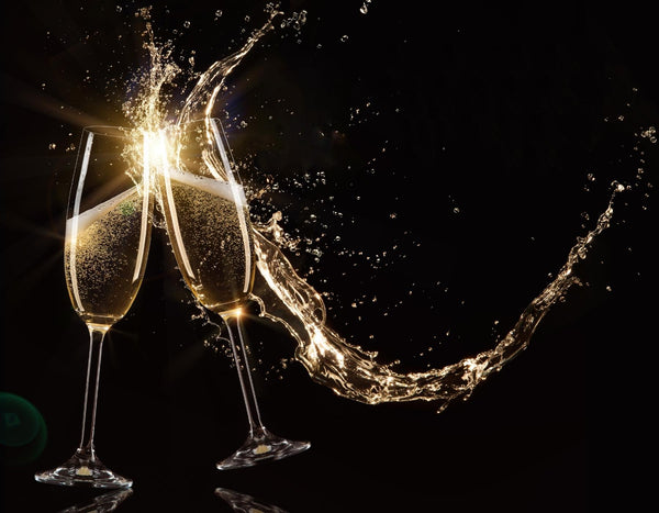 Two champagne glasses toasting with a splash, against a dark background.